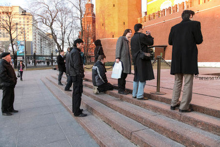 People at the Eternal flame in the Alexander garden near the Kremlin wall. The young man knelt down...