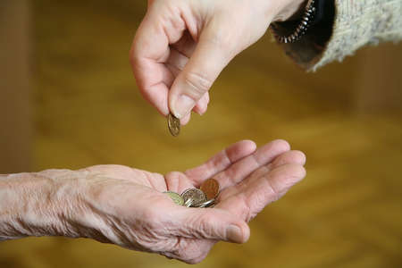 A woman gives money to an old poor woman. Closeup