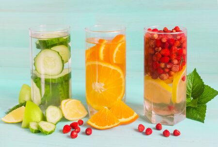 Lemonade of juicy fruit on a blue background. Summer cocktail of lemon, berries, cucumbers, orange in glass tall glasses Refreshing drink diet vegan food concept, fresh vitamins.Close-up.copy spaceの写真素材