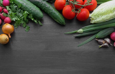 Fresh summer vegetables on a black wooden tableの写真素材