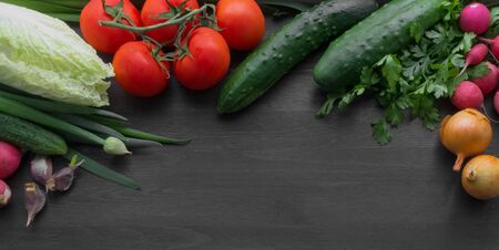 Fresh summer vegetables on a black wooden tableの写真素材