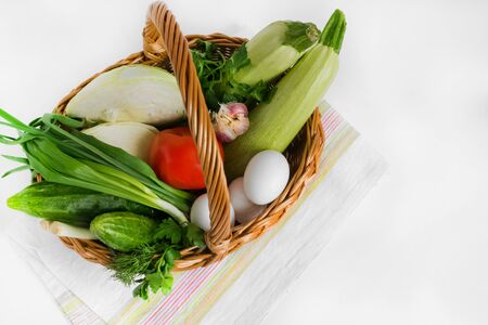 Food and groceries in a wicker shopping basket on a napkin on a white background. Consumer basket. Shop. Market. Saleの写真素材