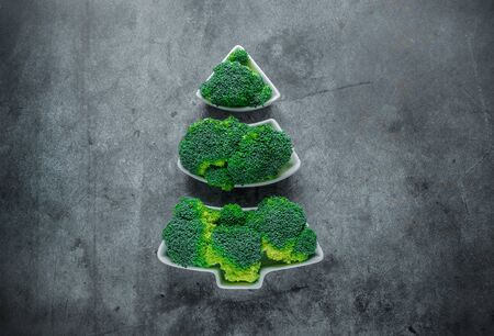 Creative edible Christmas tree made of fresh broccoli.Holiday ideas. New year food background top view .の写真素材