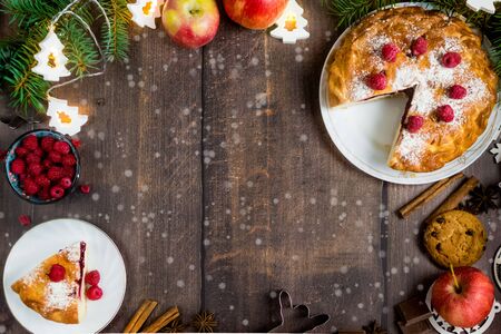 Delicious Christmas raspberry pie with berry filling and icing sugar and spices on a dark...
