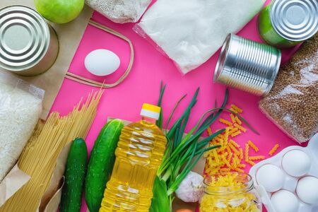 Delivery food.Paper bag with fresh food,macaroni,canned food,greens,vegetables,oil.Volunteers help with food during self-isolation and coronovirus.Donation box.flat lay.top viewの写真素材