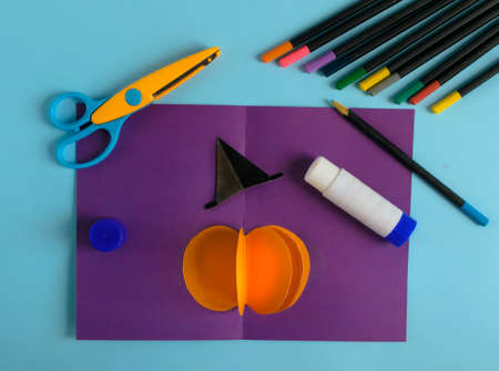 Diy Halloween card with pumpkin on purple background.Gift idea, decor Halloween.Instruction.Step by step.Top view. Children Halloween craft. Workshop.Flat lay. Step 8の写真素材