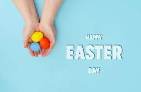 Happy Easter day.The senora is holding colorful eggs on a pink background.A greeting card or banner...