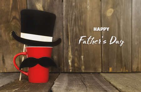Happy fathers day.A red mug with a mustache and a top hat on a rustic rustic background.A greeting card or banner for your store.Sale.Copy spaceの写真素材