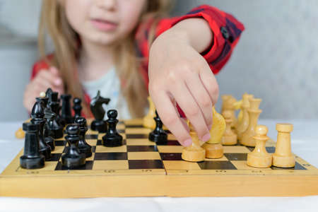 International Chess Day. A little girl learns chess pieces and learns to play chess.Table games. Family and childrens leisure. Blurred background.の写真素材