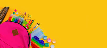 Back to school. Bright colorful school supplies and backpack for school or college on yellow background. Stationery for school children's studies. Greeting card or banner for sale. Copyspace. top viewの写真素材