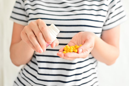 The hands of a young woman hold a jar of vitamins. Medicines for humans. Family health and womens health. world health day.の写真素材
