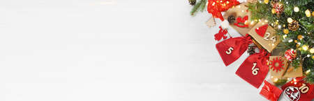 Merry Christmas. Advent calendar. Christmas gifts and surprises on a white wooden table next to...