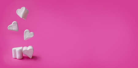 Minimalist Valentine's day. White marshmallow hearts on pink pastel background. Composition for Valentins Day, Mother's Day, March 8 or Women's Day. Greeting card or banner for sale. Copyspaceの写真素材
