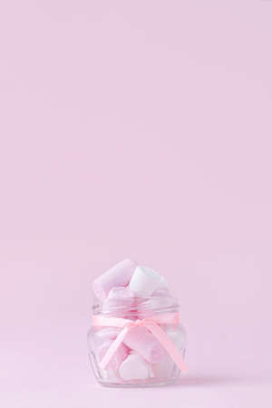 Jar of delicious pink marshmallows on pink background. A gift greeting for a holiday. Valentine's Day, Mother's Day, Women's Day. Greeting card and banner for sale. copyspace. vertical photoの写真素材
