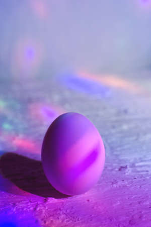 Egg on background of proton purple and yellow neon light. The cosmic universe. The concept of an...