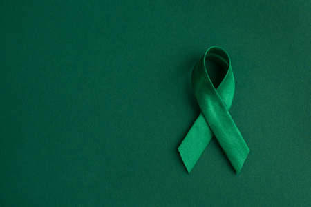world bipolar day. Green ribbon on green background. Mental health awareness day, Depression, Cerebral palsy. world kidney day. top view. copy spaceの写真素材