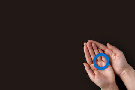 World diabetes day inscription. Blue circle in woman hands on a black background. November 14th. top...
