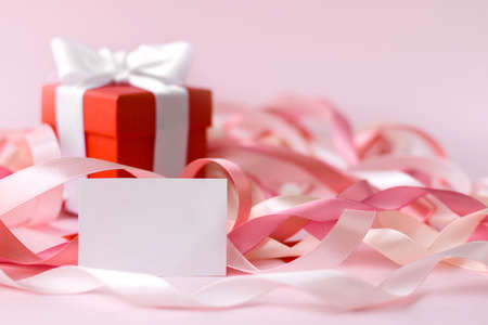 Happy Mother's Day or women's day. Valentine's day. A red box with a gift and a white greeting card...