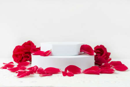 White podium for beauty cosmetics on white background with pink rose petals. Suitable for...