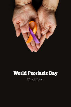 World Psoriasis Day. Woman's hands are holding a purple-orange ribbon on a black background. Treatment of skin diseases, dermatitis, eczema, psoriasis. vertical medical bannerの写真素材