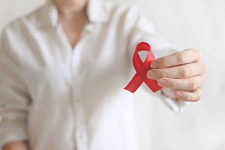 World AIDS and hiv day. Woman in white shirt holds red ribbon. Blood transfusion and donation. Hemophilia day. World Cancer Dayの写真素材