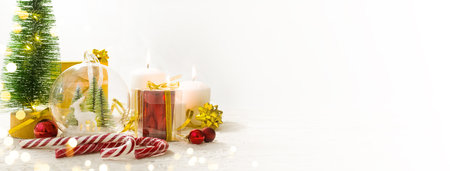 Merry Christmas. Christmas gifts, candles, surprises on white wooden table next to Christmas tree and shining lights. Advent. greeting card or banner with copyspaceの写真素材