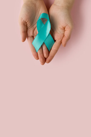Woman holding Teal ribbon. Symbolic for cervical cancer, ovarian cancer, gynecological cancer and PCOS. And sexual assault awareness.の写真素材