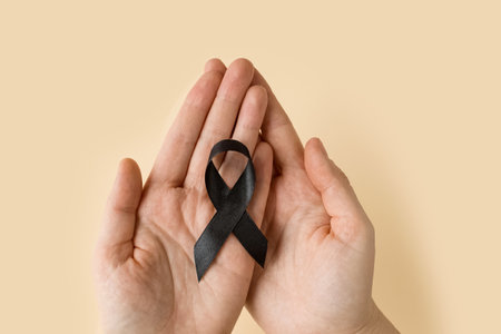 Woman holding black Ribbon for symbol Melanoma and skin cancer. Narcolepsy, Primary Biliary Cirrhosis, Sleep Apnea Disorders.の写真素材