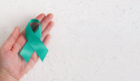 Woman holding Teal ribbon. Cervical cancer, ovarian cancer, gynecological cancer and PCOS.の写真素材