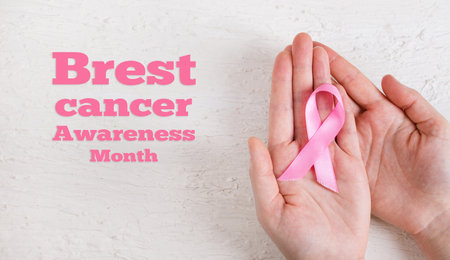 Breast Cancer Awareness Month. Hands holding pink ribbon on white background. International symbol of Breast Cancer in October. healthcare and medicine.の写真素材