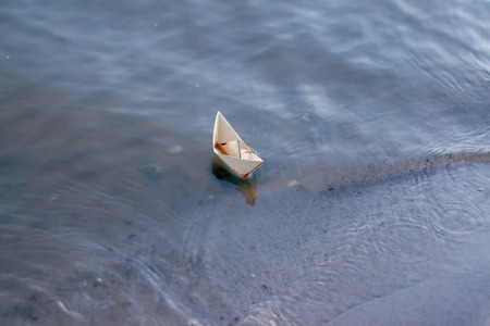 Paper boat floating on the riverの写真素材