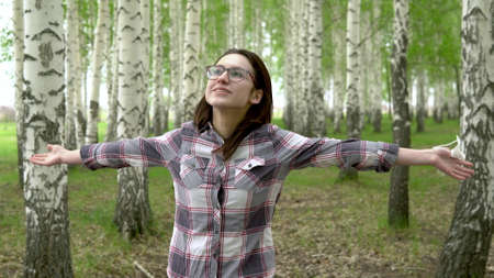 A young girl takes off a medical mask in the forest. Happy girl walks in a birch forest. The end of the pandemic.の写真素材