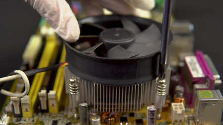 Installing a processor cooler on the motherboard. CPU cooling system on pc. View of the disassembled computer.の写真素材