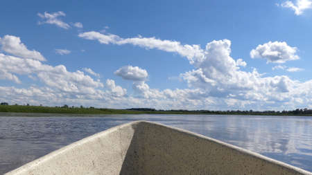 View of the river from an oar boat. Sky with clouds and blue lake.の写真素材