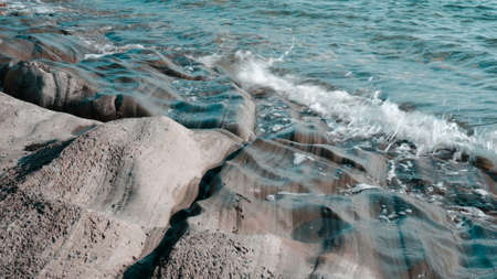 The waves hit the rocks in close-up. High tide at sea.の写真素材