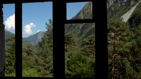 View of the green mountains from the window of an abandoned building. The camera shakes.の写真素材