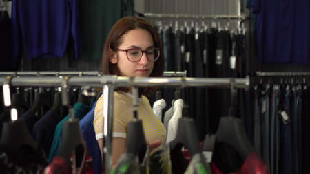 Young woman chooses clothes in the store. Clothing store.の写真素材