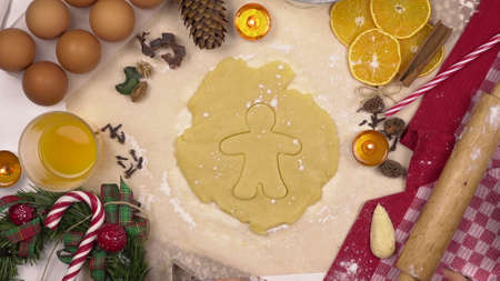 A young woman makes a traditional festive Christmas cookie in the form of a human. A figuru is...