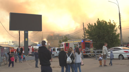 Samara, Russia - July 30, 2019: A crowd of people look at putting out a building fireのeditorial素材