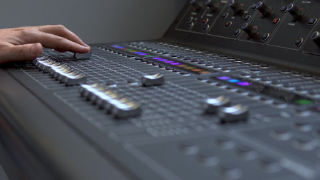 Man works on a professional electronic audio mixer. A control panel for tuning sound channels.の写真素材