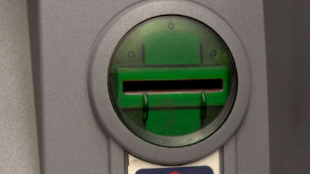 ATM close-up. The card entry slot blinks green. ATM for cash withdrawal and deposit.の写真素材