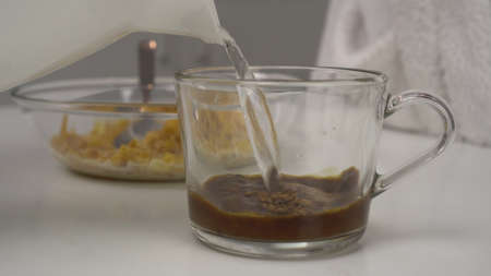 Young woman makes instant coffee with milk.の写真素材