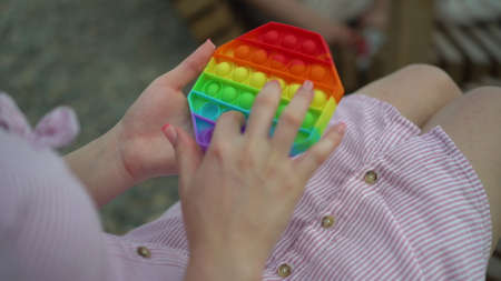 A young woman sits with antistress toy in her hands.の写真素材