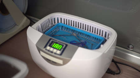 A woman puts tools in a water sterilizer. Sterilization of instruments.の写真素材