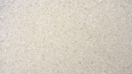 Sugar crystals fall on glass on a bright white background. Macro view of sugar.の写真素材
