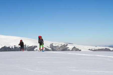 Winter hiking in the mountains on snowshoes with a backpack and tent.の写真素材