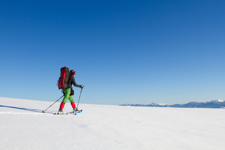 Winter hiking in the mountains on snowshoes with a backpack and tent.の写真素材