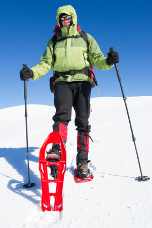 Winter hiking in the mountains on snowshoes with a backpack and tent.の写真素材
