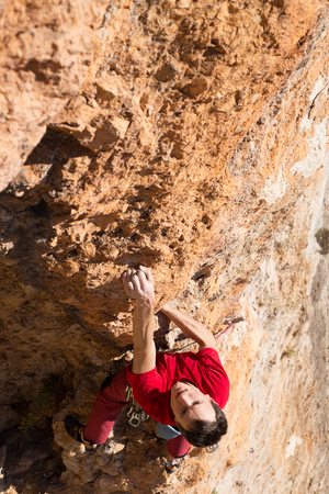 Young male climber hanging by a cliff.の写真素材