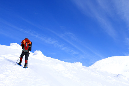 Winter hiking in the mountains on snowshoes with a backpack and tent.の写真素材